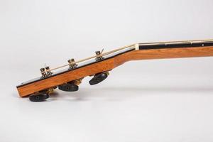 Tuning pegs on wooden machine head of six strings guitar on white background photo