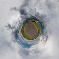 pequeño planeta transformación de panorama esférico 360 grados. vista aérea abstracta esférica en el campo en una agradable velada con impresionantes nubes hermosas. curvatura del espacio. foto