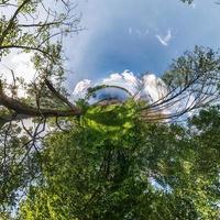 Little planet transformation of spherical panorama 360 degrees. Spherical abstract aerial view in field with awesome beautiful clouds. Curvature of space. photo