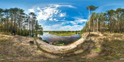 vista de ángulo de 360 grados de panorama hdri esférico completo con alto acantilado de arena cerca de la orilla del río en un bosque de pinos en proyección equirectangular, listo para contenido de realidad virtual ar vr foto