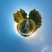 Little planet transformation of spherical panorama 360 degrees. Spherical abstract aerial view in field with awesome beautiful clouds. Curvature of space. photo