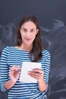 woman using tablet  in front of chalk drawing board photo