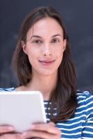 woman using tablet  in front of chalk drawing board photo