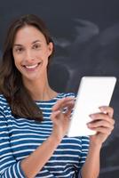 woman using tablet  in front of chalk drawing board photo