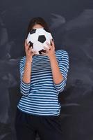 woman holding a soccer ball in front of chalk drawing board photo