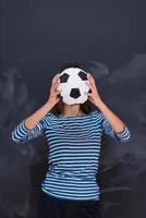 woman holding a soccer ball in front of chalk drawing board photo