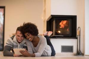 multiethnic couple using tablet computer on the floor photo