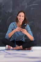 mujer sosteniendo un cable de internet frente a un tablero de dibujo de tiza foto