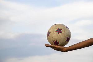 viejo y sucio balón de fútbol en la mano foto