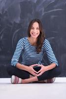 woman sitting in front of chalk drawing board photo