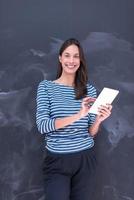 woman using tablet  in front of chalk drawing board photo