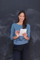 woman using tablet  in front of chalk drawing board photo