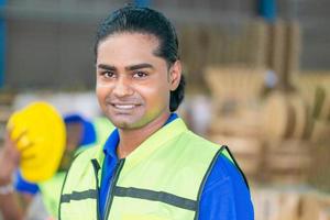 Portrait of Worker wearing safety vest standing in the warehouse, Man looking at camera with blurred background and copy space photo