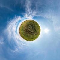 Little planet transformation of spherical panorama 360 degrees. Spherical abstract aerial view in field with awesome beautiful clouds. Curvature of space. photo