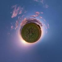 Little planet transformation of spherical panorama 360 degrees. Spherical abstract aerial view in field with awesome beautiful clouds. Curvature of space. photo