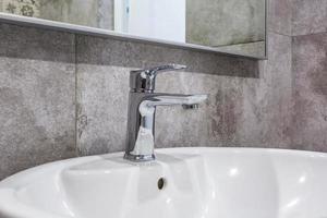 Fregadero de agua de acero con grifo en baño de loft caro foto