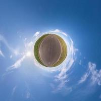 Little planet transformation of spherical panorama 360 degrees. Spherical abstract aerial view in field with awesome beautiful clouds. Curvature of space. photo