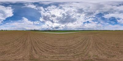 panorama hdri esférico completo sin costuras vista en ángulo de 360 grados entre campos en la tarde de primavera con nubes asombrosas antes de la tormenta en proyección equirectangular, listo para contenido de realidad virtual vr ar foto