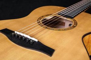 textura de madera de la cubierta inferior de guitarra acústica de seis cuerdas sobre fondo negro. forma de guitarra foto