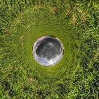 Little planet transformation of spherical panorama 360 degrees. Spherical abstract aerial view in field with awesome beautiful clouds. Curvature of space. photo