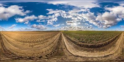 panorama hdri esférico completo sin costuras vista en ángulo de 360 grados en camino de grava sin tráfico entre campos en primavera con cielo nublado en proyección equirectangular, listo para contenido de realidad virtual vr ar foto