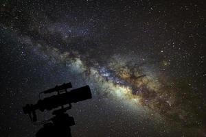 Silhouette of telescope watching the milky way galaxy on night sky photo