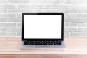 Front view of the laptop is on the work table white brick background photo