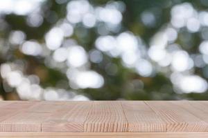 mesa de madera sobre fondo verde bokeh - se puede utilizar para montar o mostrar sus productos foto