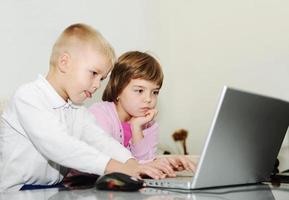 childrens have fun and playing games on laptop computer photo