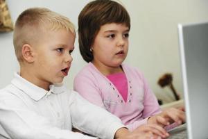 childrens have fun and playing games on laptop computer photo