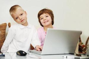 childrens have fun and playing games on laptop computer photo