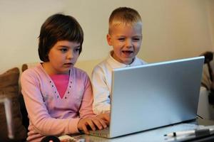 childrens have fun and playing games on laptop computer photo