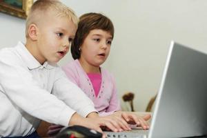 childrens have fun and playing games on laptop computer photo