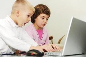 childrens have fun and playing games on laptop computer photo