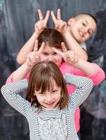 group of kids standing in front of chalkboard photo