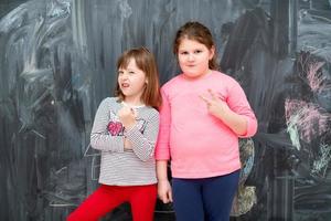 portrait of little girls in front of chalkboard photo