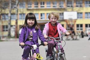 grupo de niños felices aprendiendo a conducir bicicleta foto