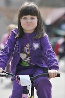 cute little girl driving bicyle at sunny day photo