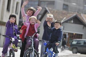 grupo de niños felices aprendiendo a conducir bicicleta foto