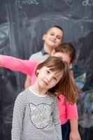 group of kids standing in front of chalkboard photo