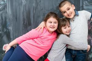 group of kids hugging in front of chalkboard photo