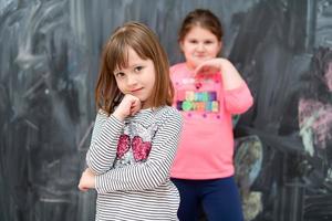 portrait of little girls in front of chalkboard photo