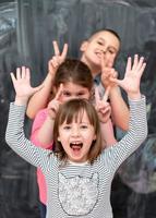 group of kids standing in front of chalkboard photo