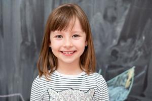 portrait of little girl in front of chalkboard photo
