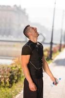 man pouring water from bottle on his head photo