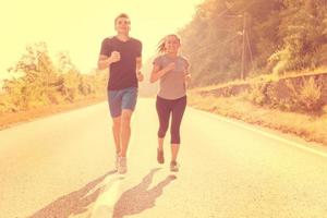 pareja joven trotando a lo largo de un camino rural foto