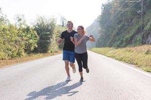 young couple jogging along a country road photo