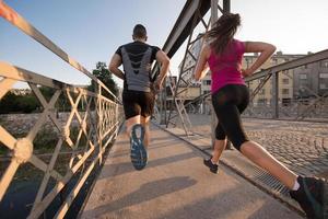pareja joven corriendo por el puente en la ciudad foto