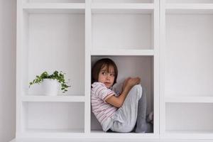 young boy posing on a shelf photo