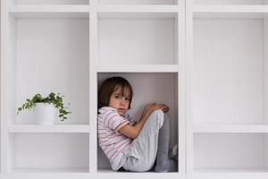 young boy posing on a shelf photo